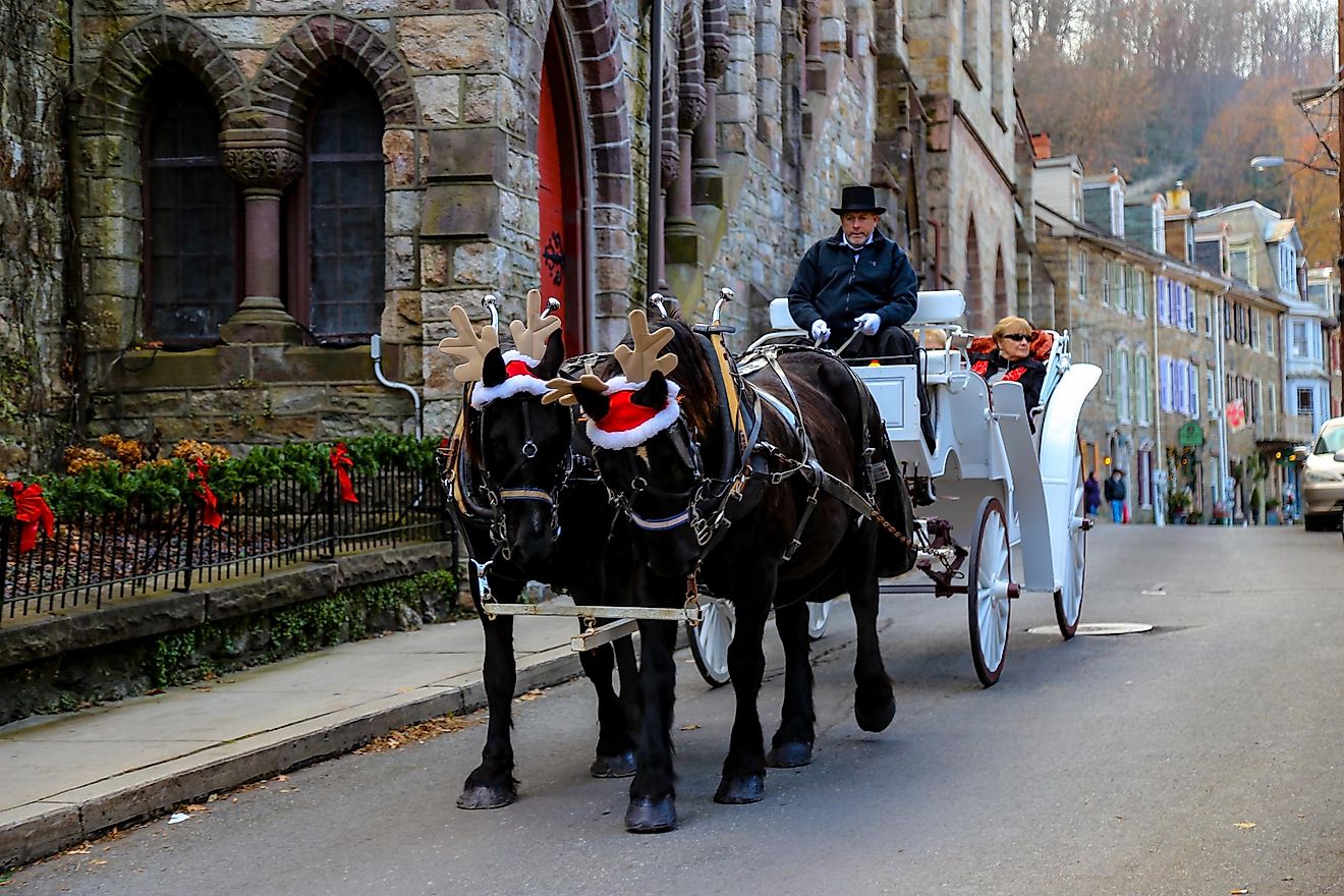 Horses wearing Santa hats and reindeer antlers pulling a white carriage through the picturesque town of Jim Thorpe, Pennsylvania, USA. Editorial credit: George Sheldon / Shutterstock.com