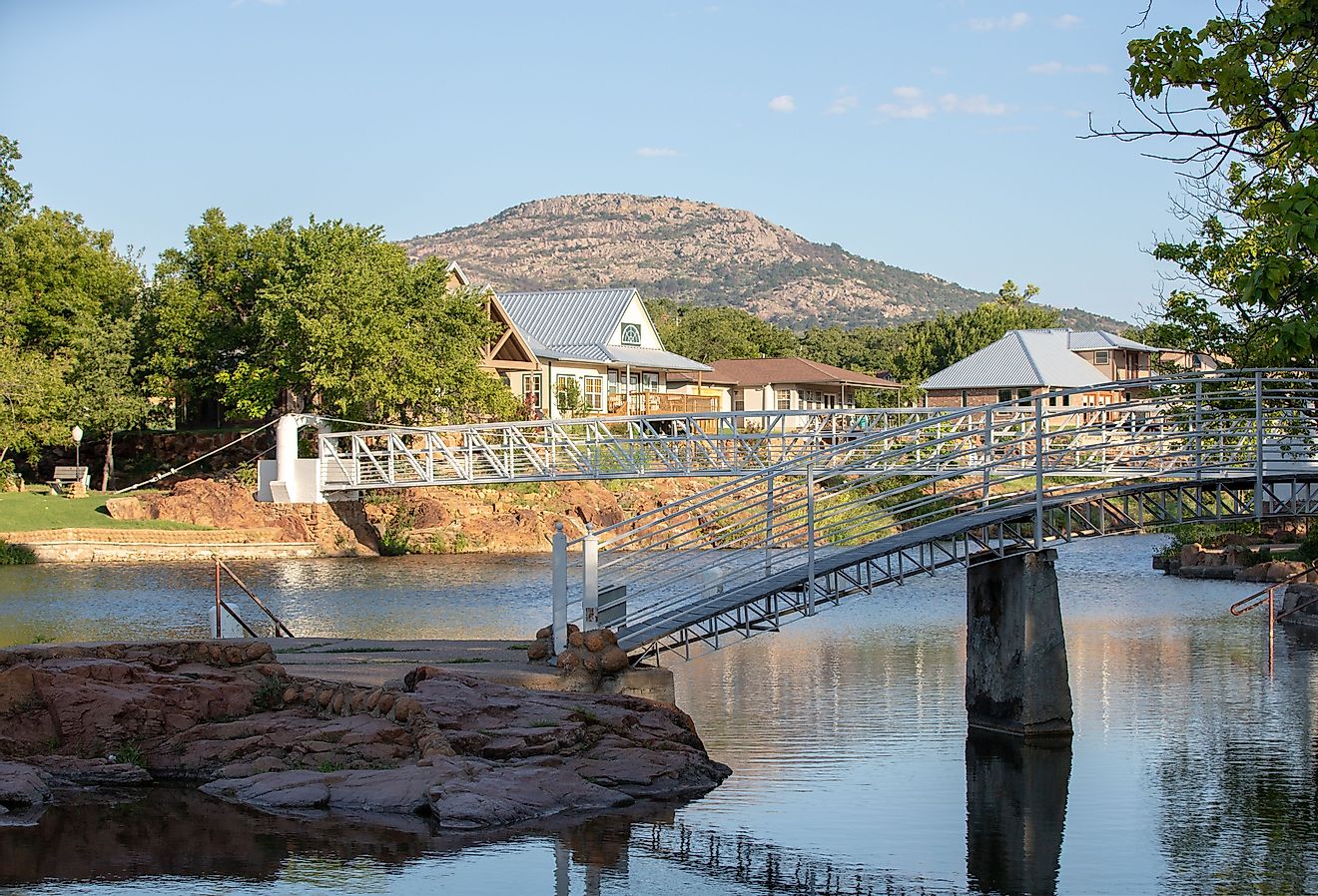 Metal bridge over water and mountain in the background in Medicine Park, Lawton, Oklahoma.