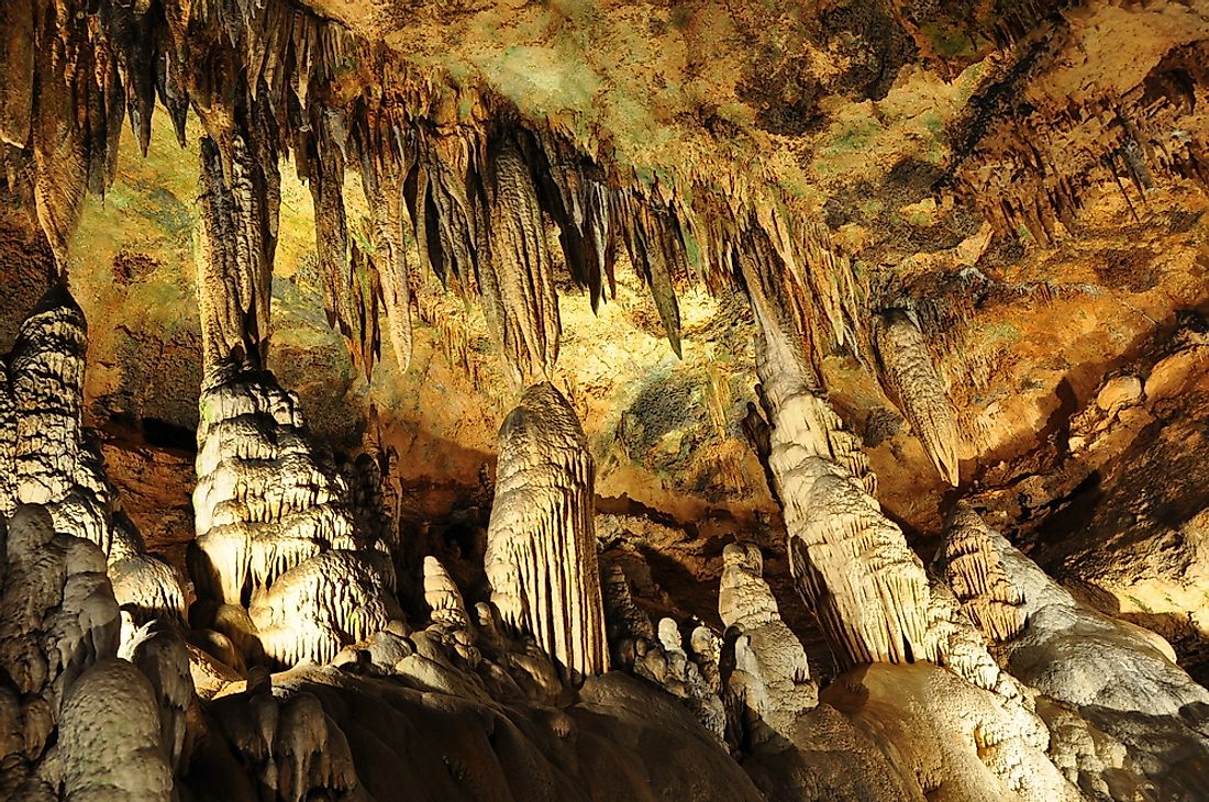 Stalactites hang from the ceiling in a cave. 