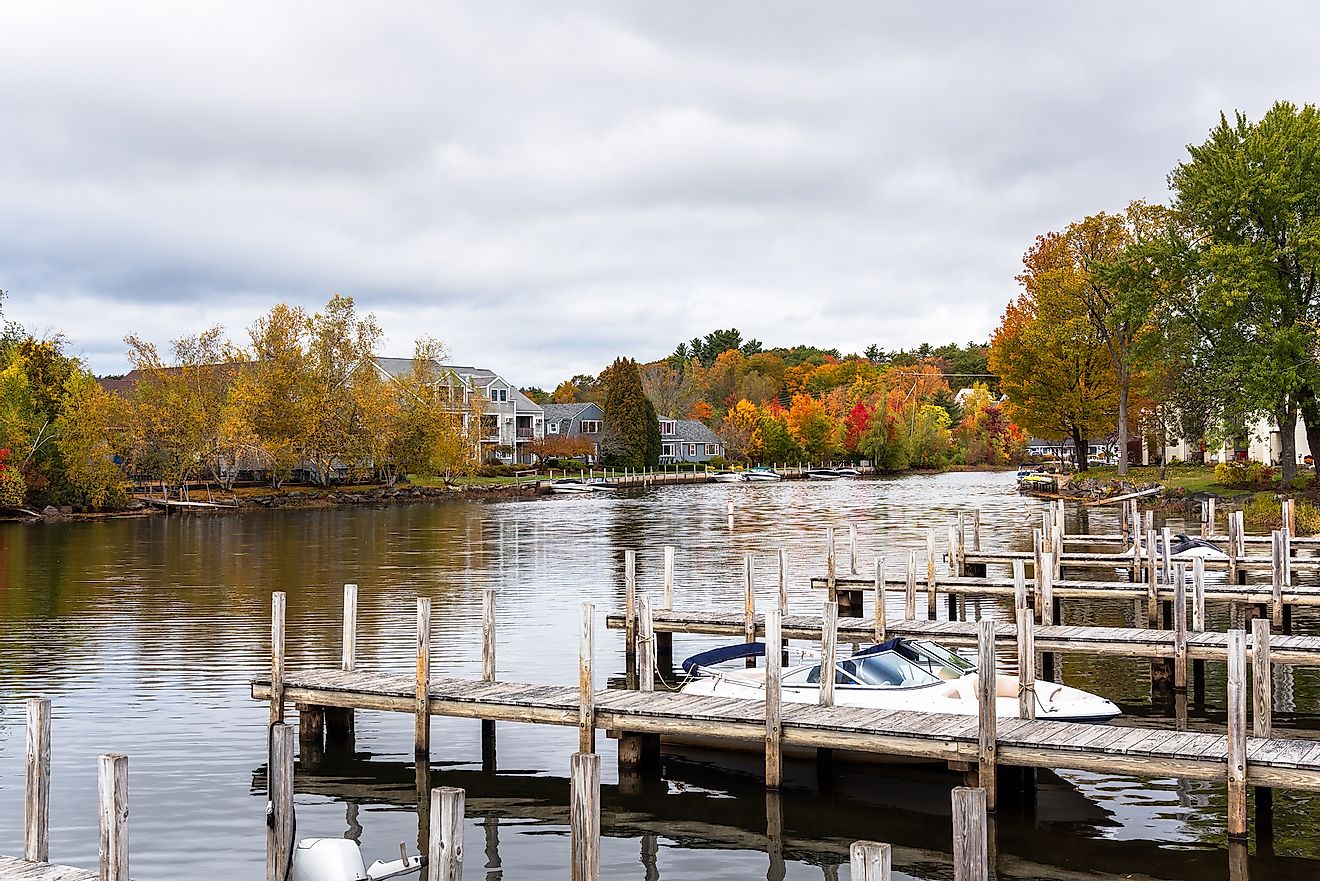 Colorful autumnal trees on river bank in Wolfeboro, New Hampshire, US.