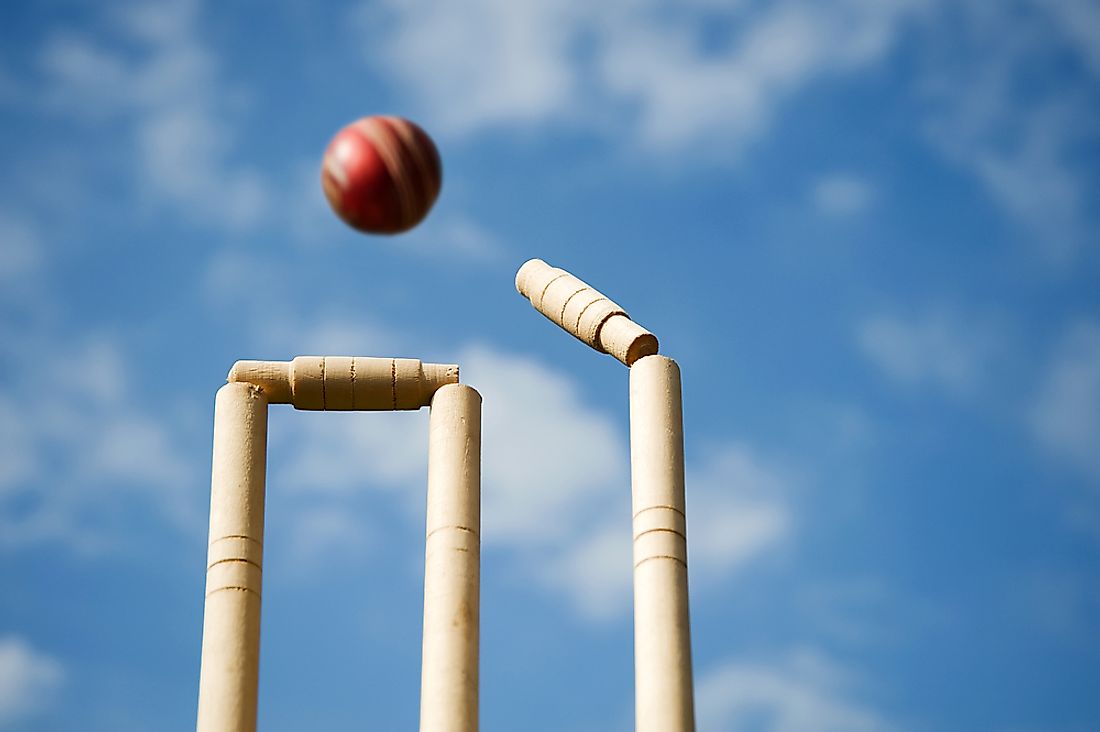 A cricket ball hitting bails and stumps. 