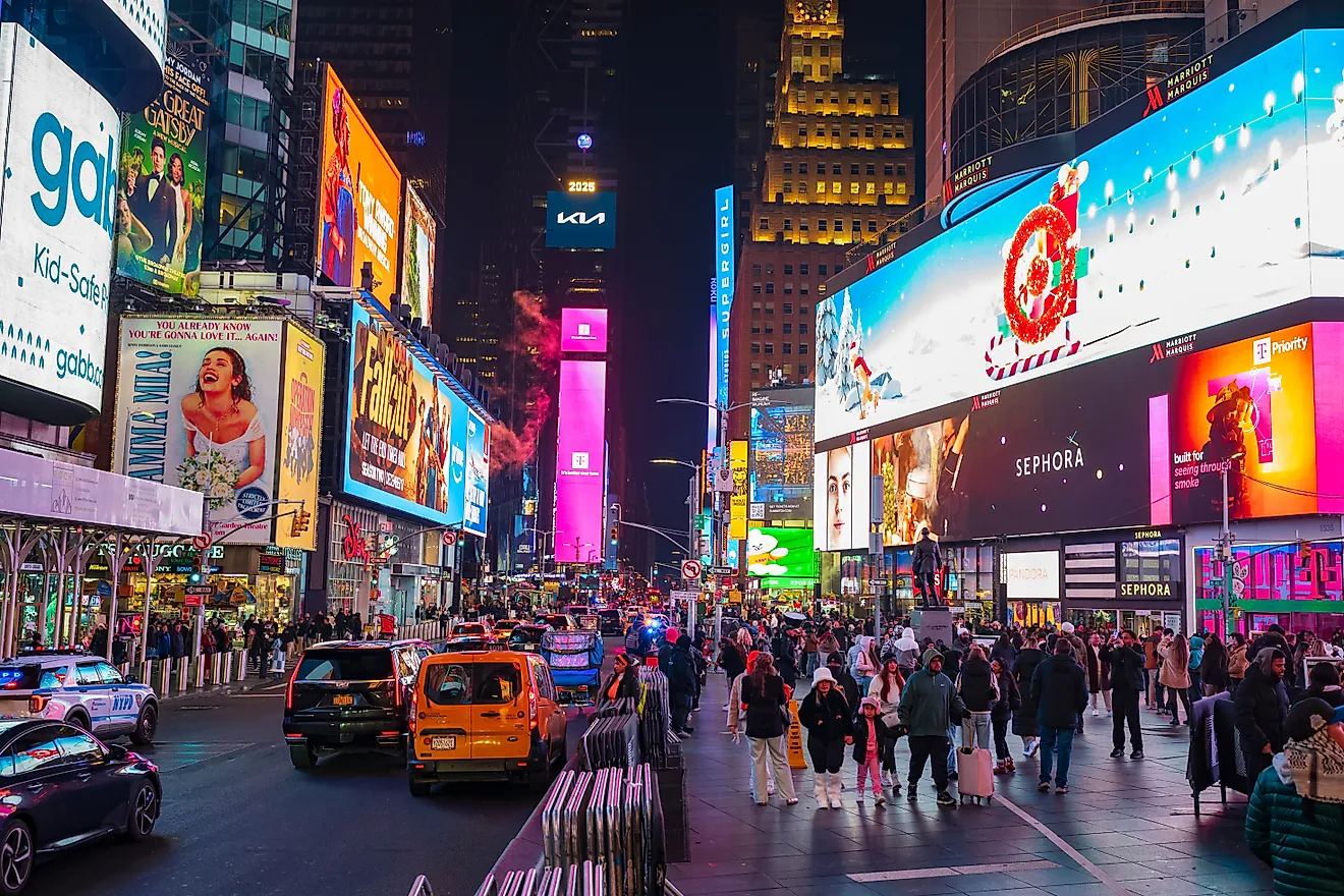 Tourist explore the famous Times Square in the heart of Manhattan at night.