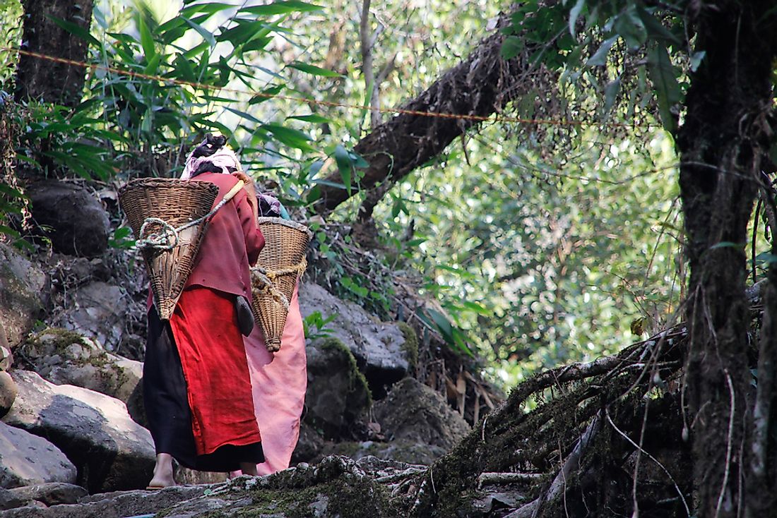 Khasi women carry stones in a basket in Meghalaya, India.  Editorial credit: gregorioa / Shutterstock.com.