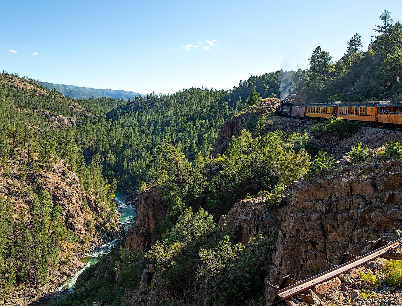 Historic steam engine train through San Juan Mountains and Animas river in Colorado.