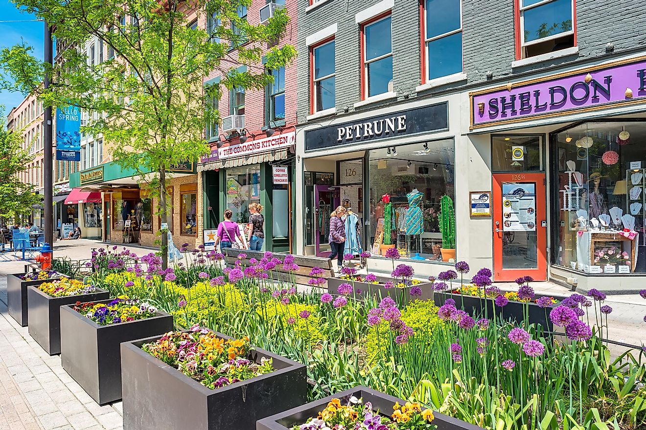 People walk past colorful stores in a pedestrian area of downtown Ithaca, New York