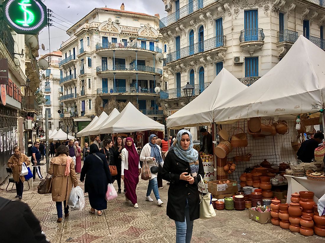 Algerian people walk in a market in Algiers. Editorial credit: Oguz Dikbakan / Shutterstock.com.
