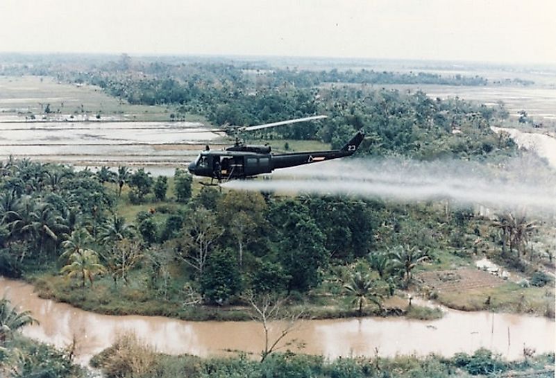 A U.S. Army helicopter destroying Vietnamese croplands by way of Agent Orange application from above during the Vietnam War.