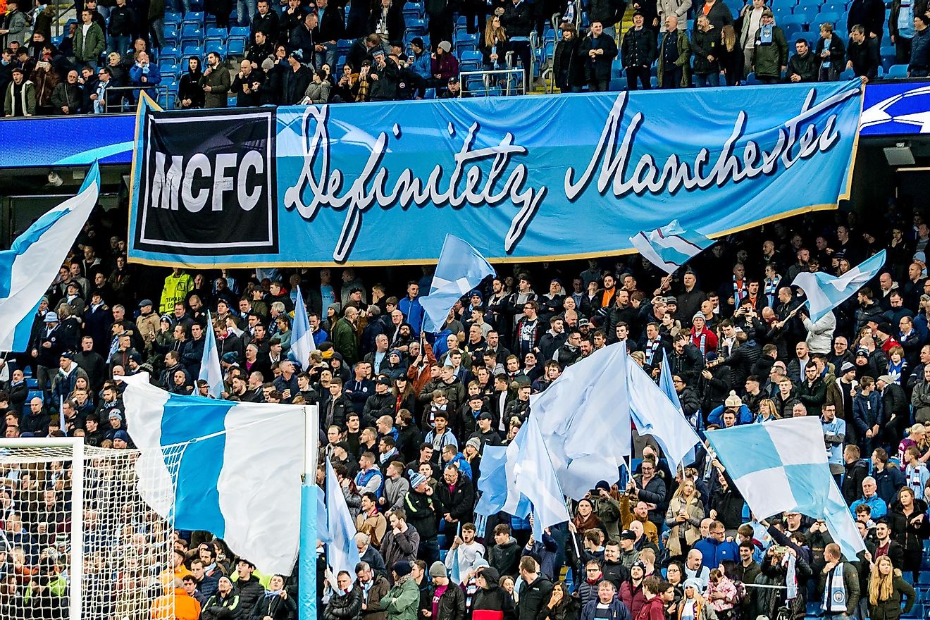 Fans and supporters with mcfc definitely manchester banner During the Champions League match Manchester City - Feyenoord at the Etihad Stadium. Credit: kivnl / Shutterstock.com