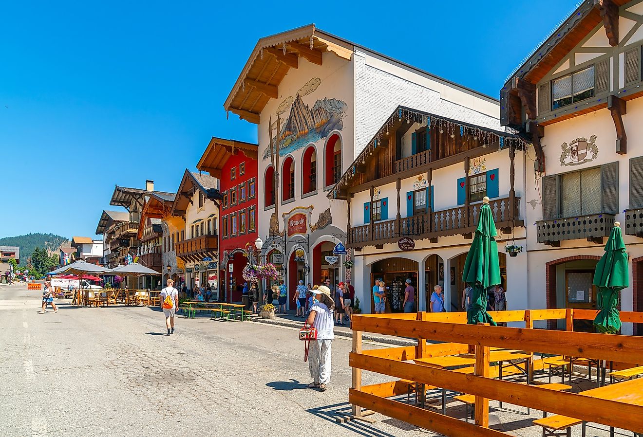 Shops and sidewalk cafes line the quaint Bavarian themed main street of the tourist resort town of Leavenworth, Washington. Image credit Kirk Fisher via Shutterstock