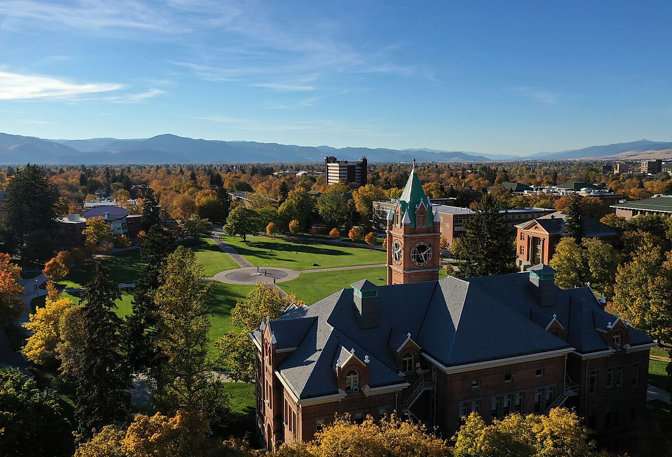 Looking northeast over the Main Hall clock tower and The Oval at the University of Montana during Autumn, with the Missoula Valley stretching out into the distance.