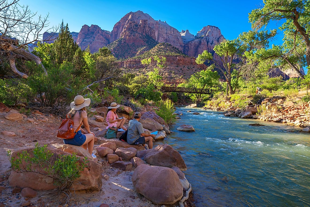 isitors relax by a river in Zion National Park near Springdale, Utah.
