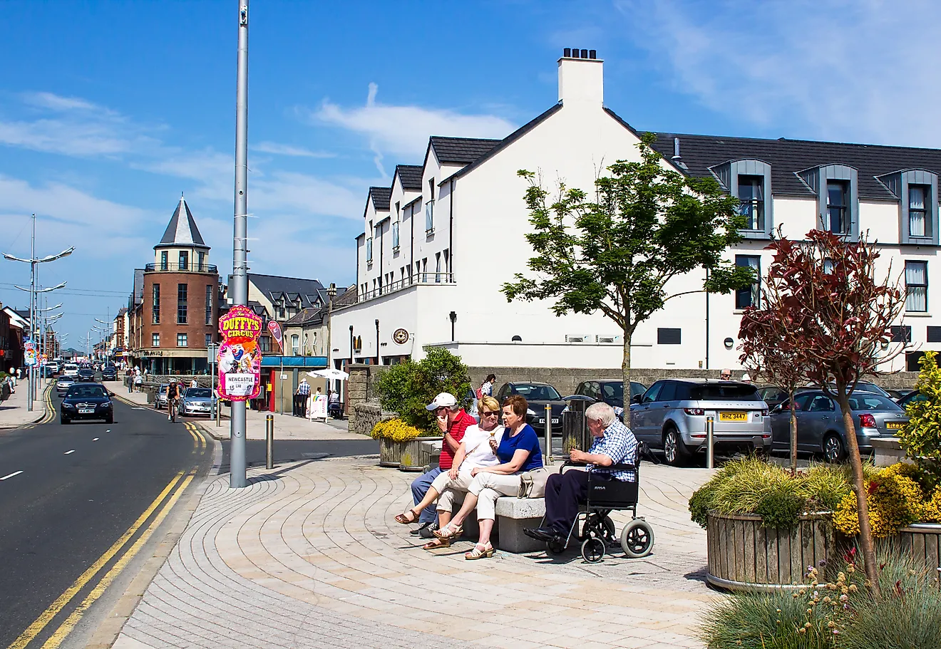  People sitting while chatting outside the Newcastle Centre on the central promenade in Newcastle County Down Northern Ireland