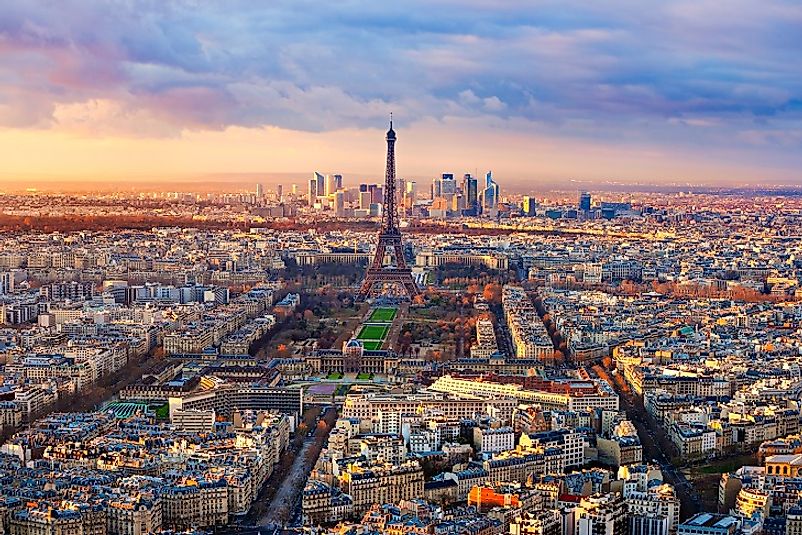 The Eiffel Tower, a symbol iconic of the nation of France as a whole, rises up from amidst Paris's  urban expanse.