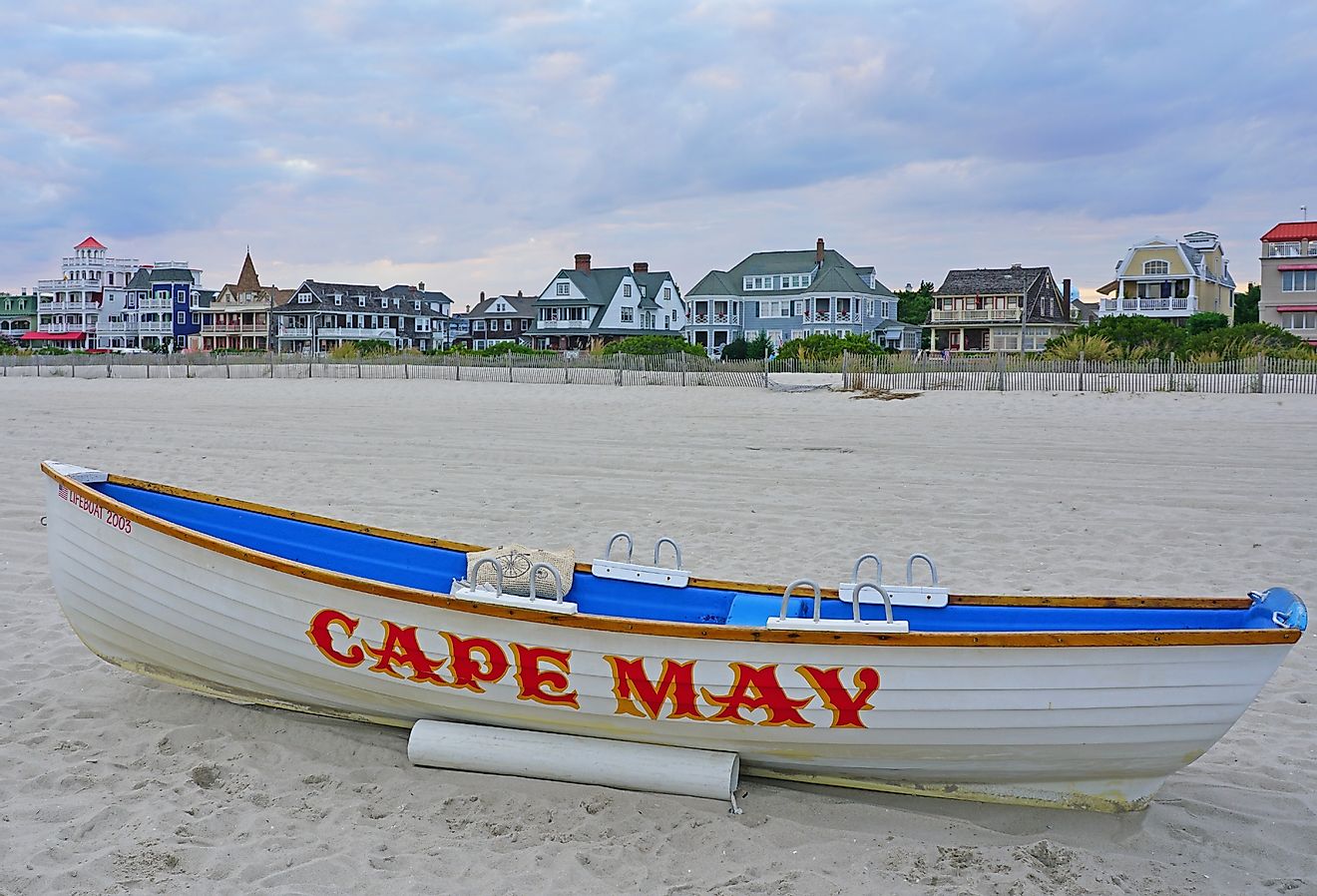 View of a boat with a Cape May sign on the beach in Cape May, New Jersey. Image credit EQRoy via Shutterstock