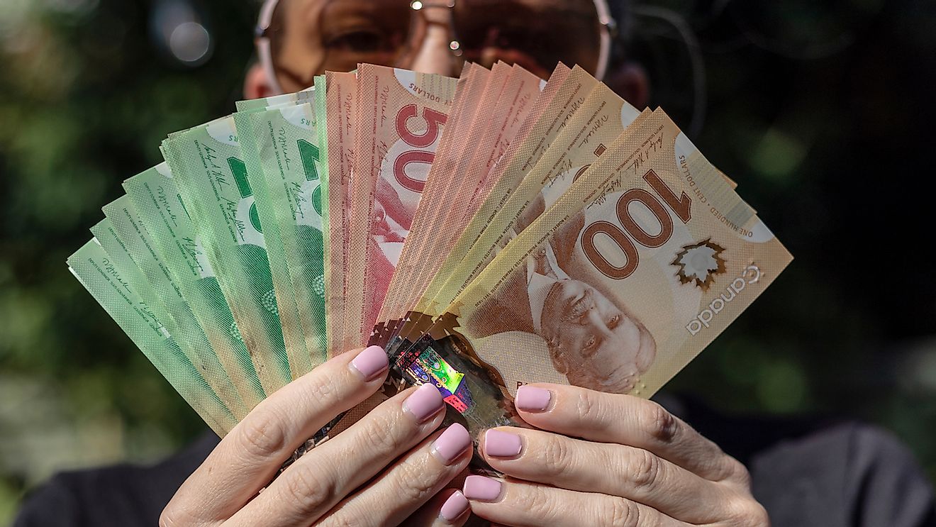 A Woman Fanning Out Canadian Cash. Image credit: Stefan Malloch/Shutterstock.com