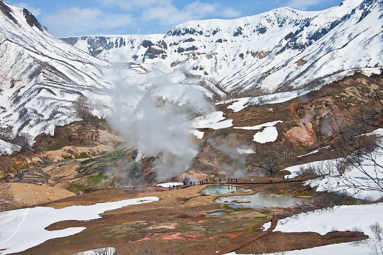 Tourists during the tour at the thermal field in the Valley of Geysers in Kronotsky reserve. Kamchatka, Russia. Image credit: Okyela/Shutterstock.com