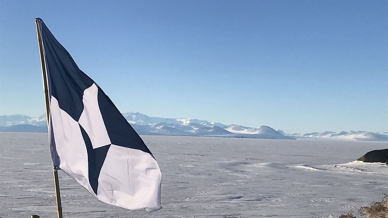 The flag of Antarctic flies above the Ross Ice Shelf near McMurdo Station, Antarctica
