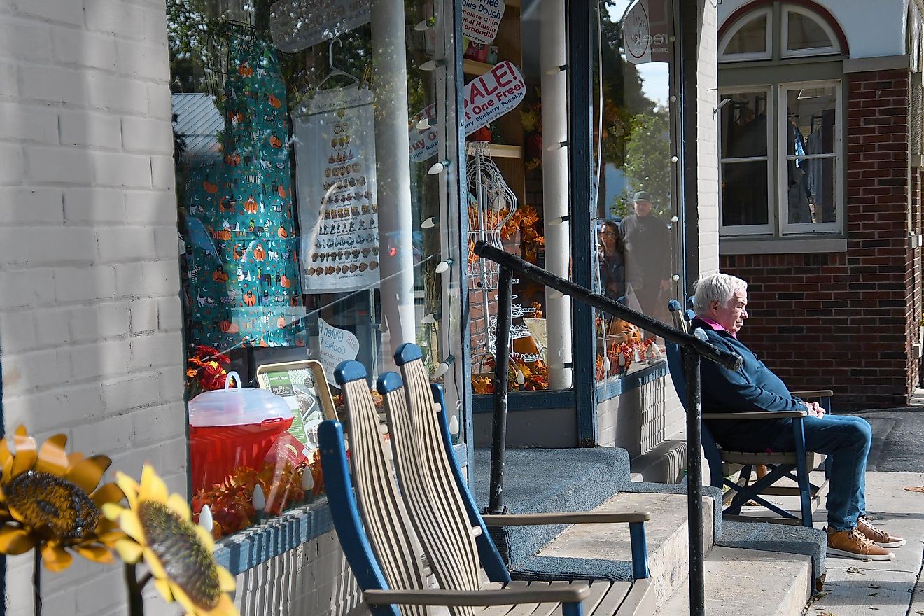 Cedarburg, Wisconsin / USA - September 28, 2019: An Elderly Man Sits Alone and Abandoned on a Bench in Front of a Storefront