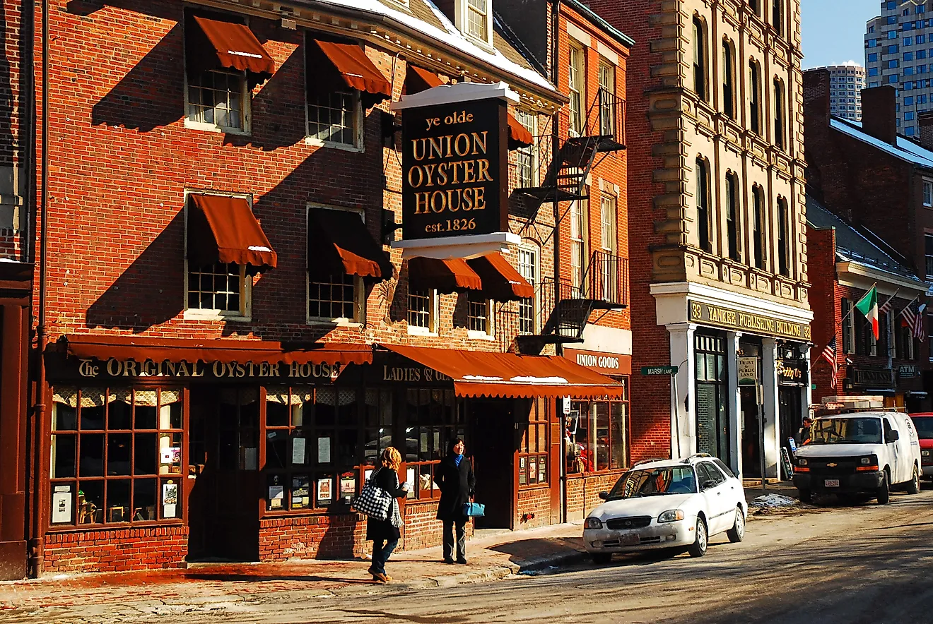 A young couple walks under the awning and sign of the Ye Olde Union Oyster House, in Boston, on a cold winter day. Credit: James Kirkikis/ Shutterstock