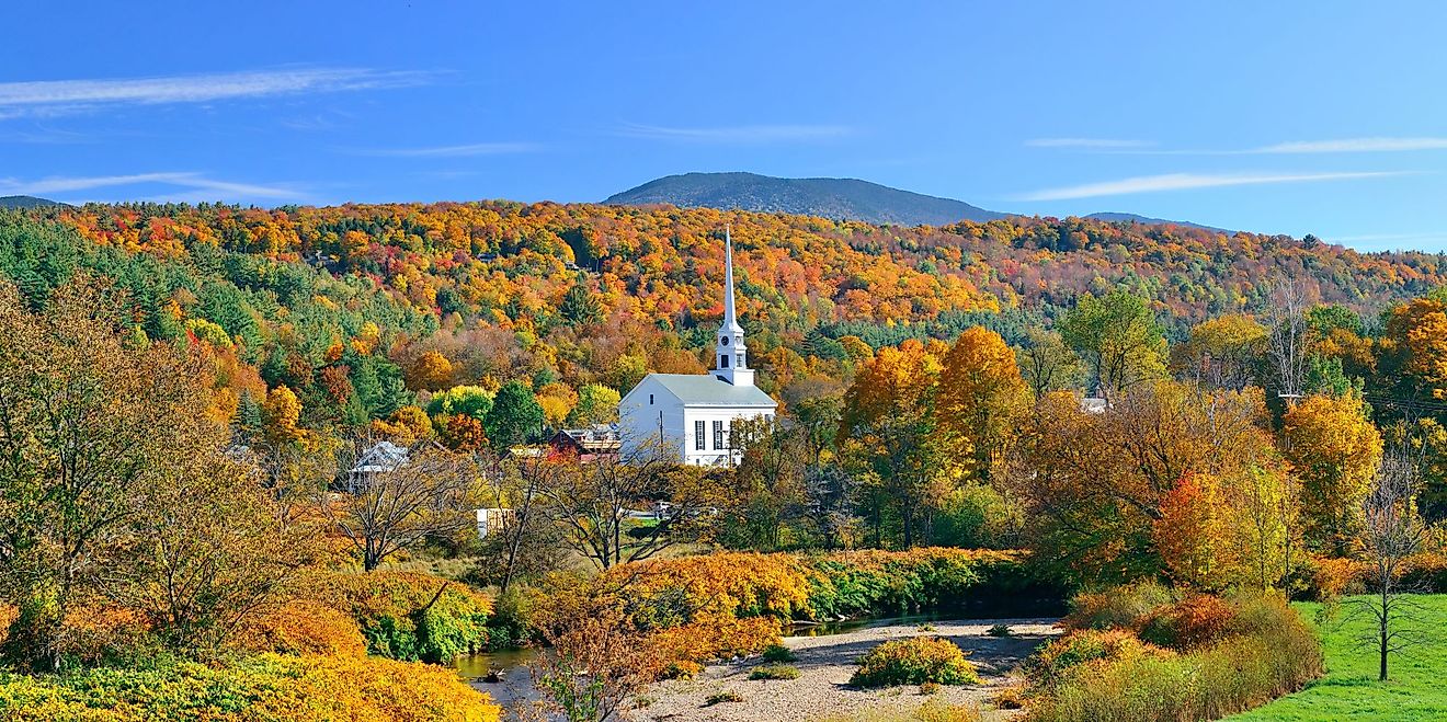 Stowe panorama in Autumn with colorful foliage and community church in Vermont. 