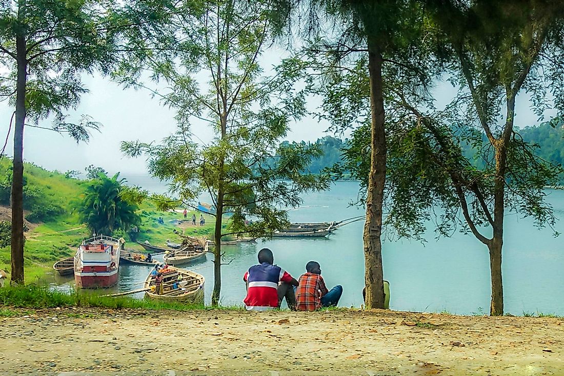 Rwandan men sit by a lake. 
