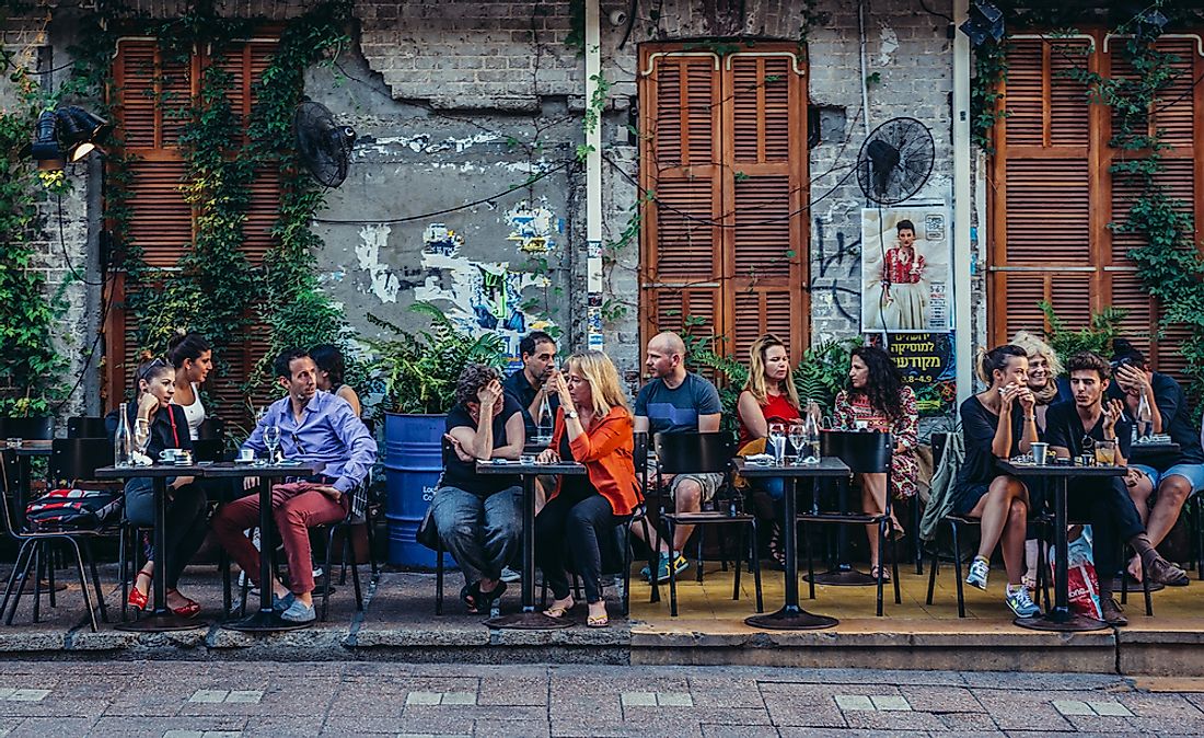 People at a cafe in Tel Aviv, Israel. Editorial credit: Fotokon / Shutterstock.com.