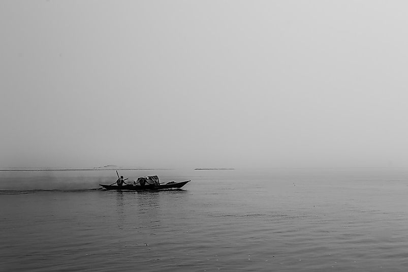 Local Bangladeshi boatsman traveling upon the wide expanses of the Jamuna River.