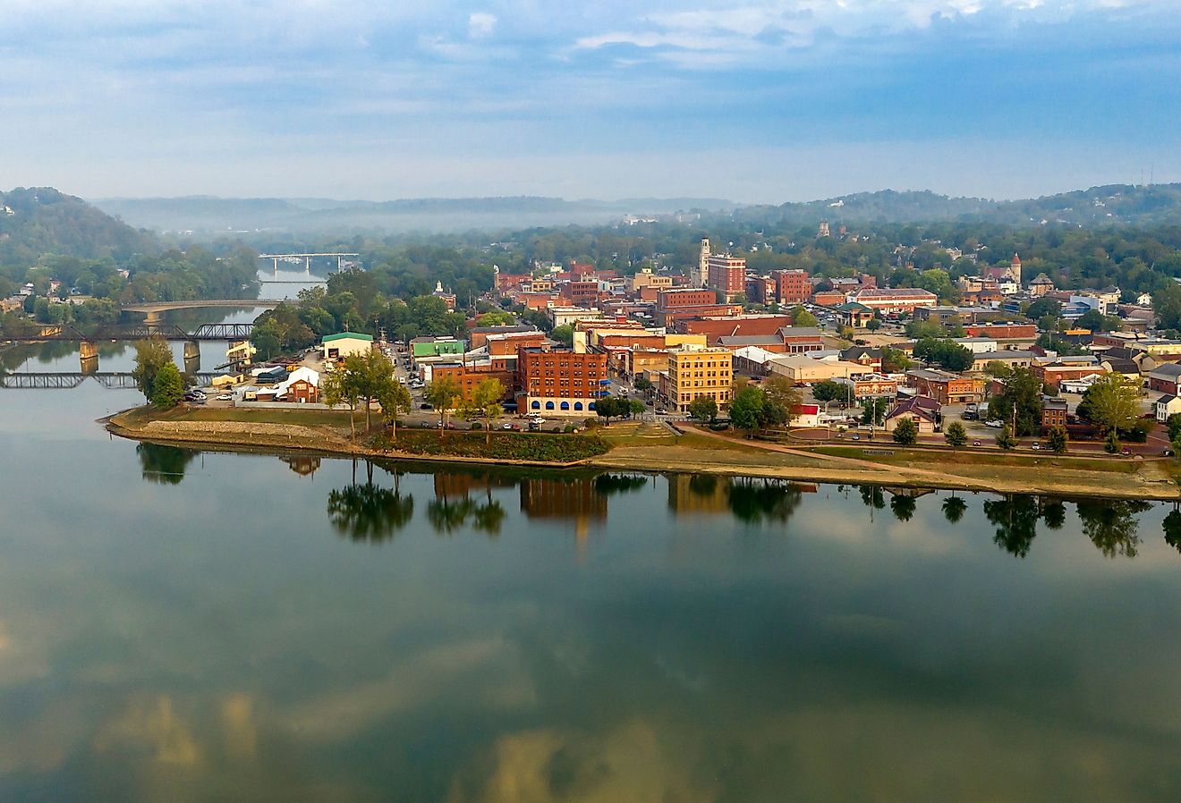 The scenic Ohio River along the town of Marietta, Ohio with green trees and rolling hills in the background.