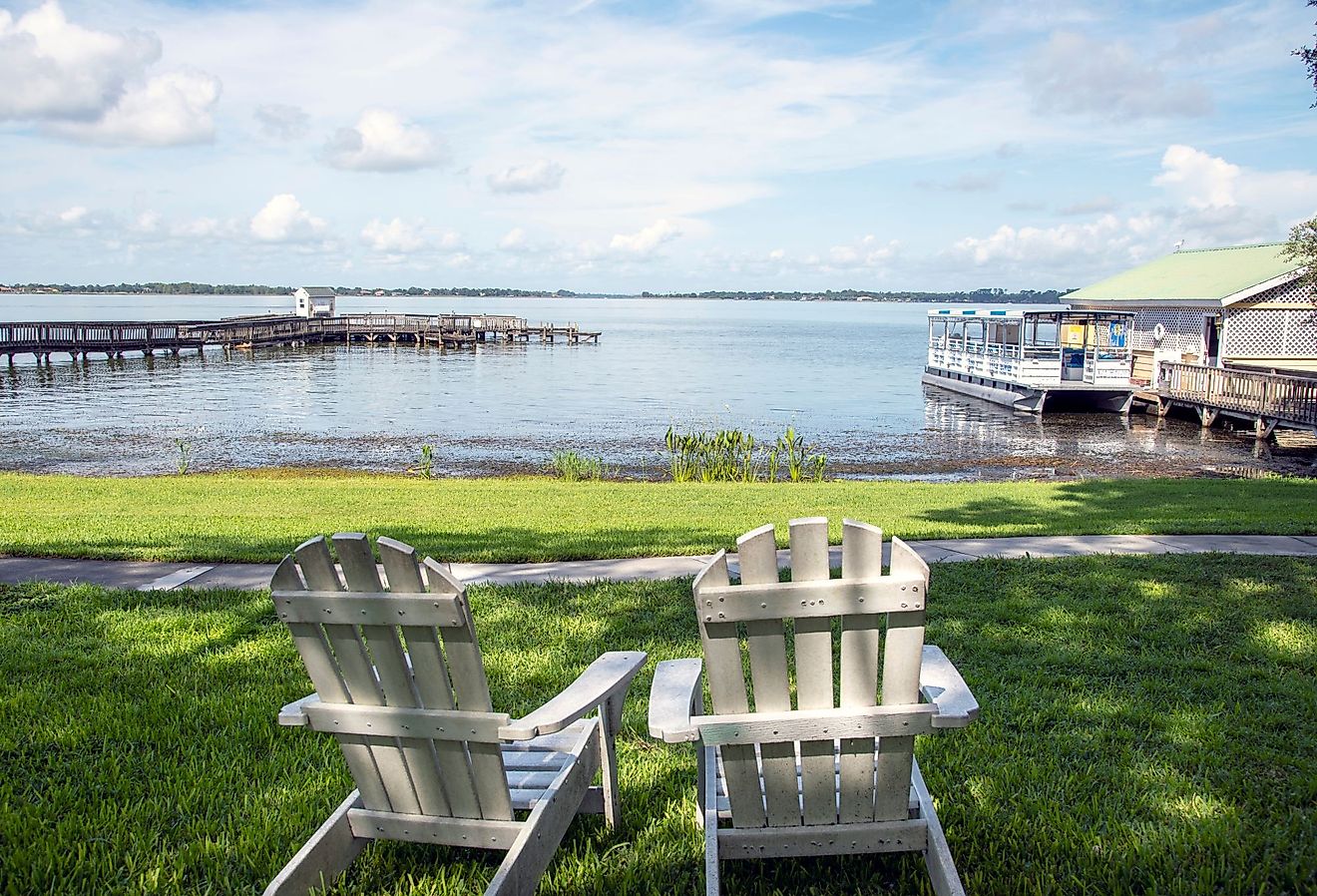 Two chairs on a green lawn overlooking Dora Lake and piers. Editorial credit: Marty-Mac / Shutterstock.com