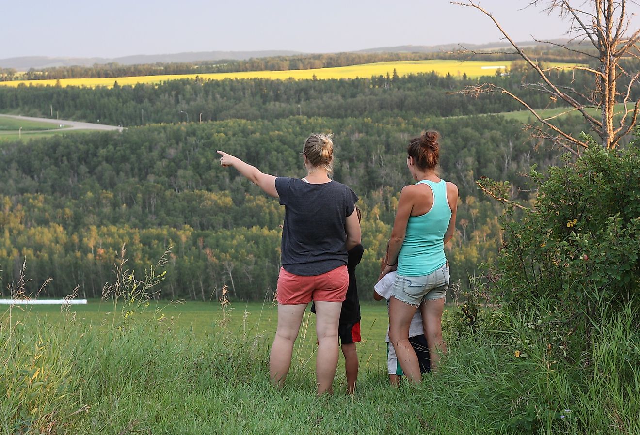 A woman pointing towards the Red Deer river valley, near Lacombe, Alberta. Image credit Carol Provins via Shutterstock