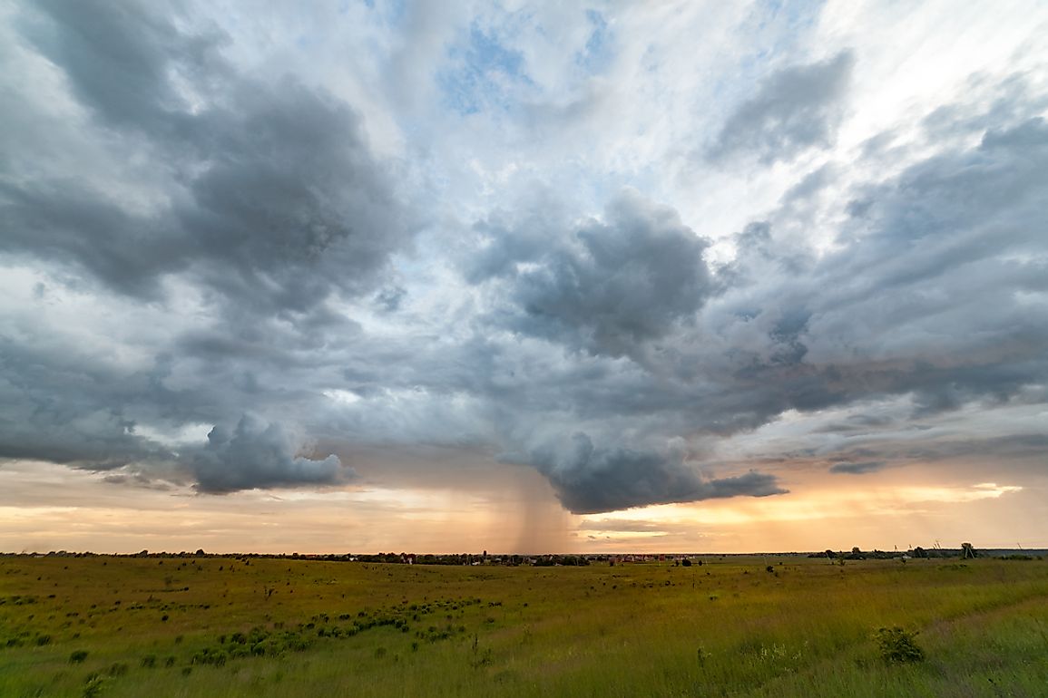 A tornado seen stirring up soil and ground at dusk.