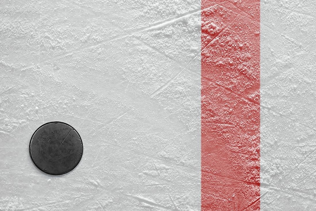 A puck is shown on a hockey ice rink in an arena.