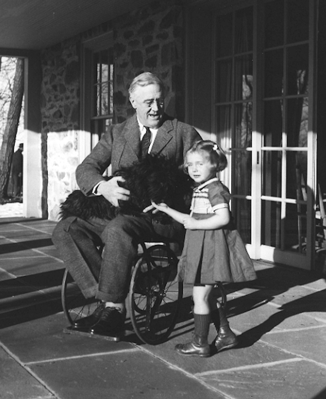 Rare photograph of Roosevelt in a wheelchair, with Fala and Ruthie Bie, the daughter of caretakers at his Hyde Park estate. Image credit: Margaret Suckley/Public domain 