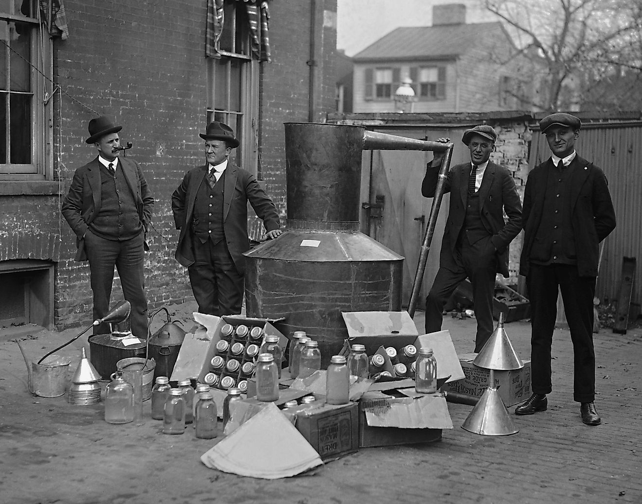Prohibition agents stand with a still and mason jars used to distill hard liquor in Wash. D.C. area. Nov. 11, 1922. Credit: Everett Historical / Shutterstock.com