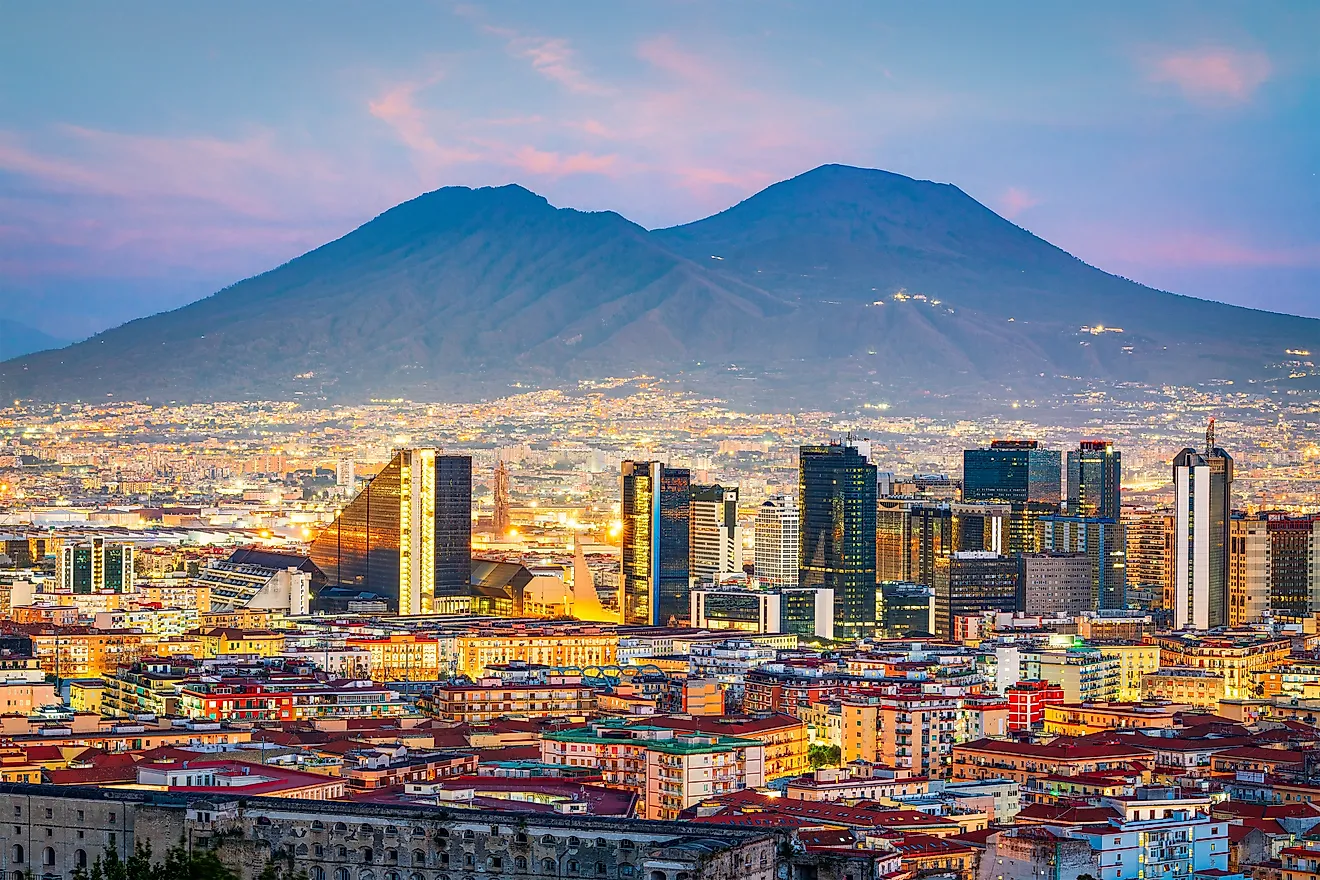Naples, Italy with the financial district skyline under Mt. Vesuvius at twilight.