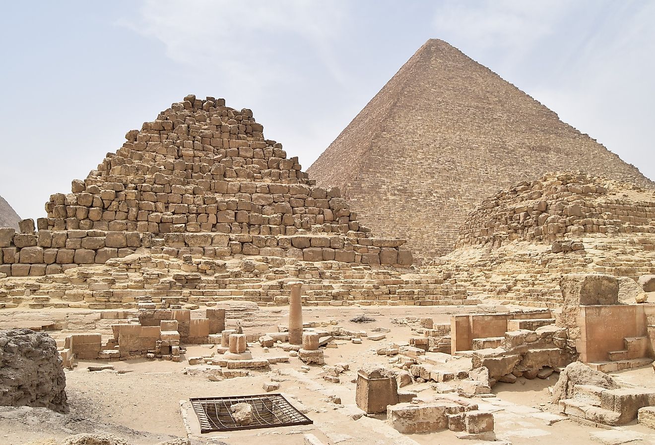Pyramids of Giza complex in Cairo, Egypt, with Menkaure, Khafre, and Khufu pyramids under clear desert sky.