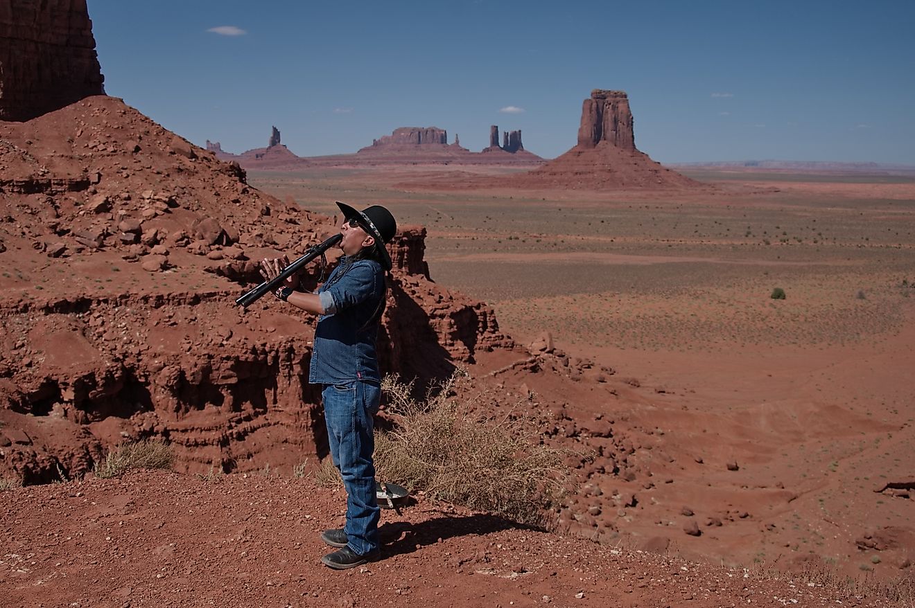 A member of the Navajo tribe playing flute in Monument Valley. 