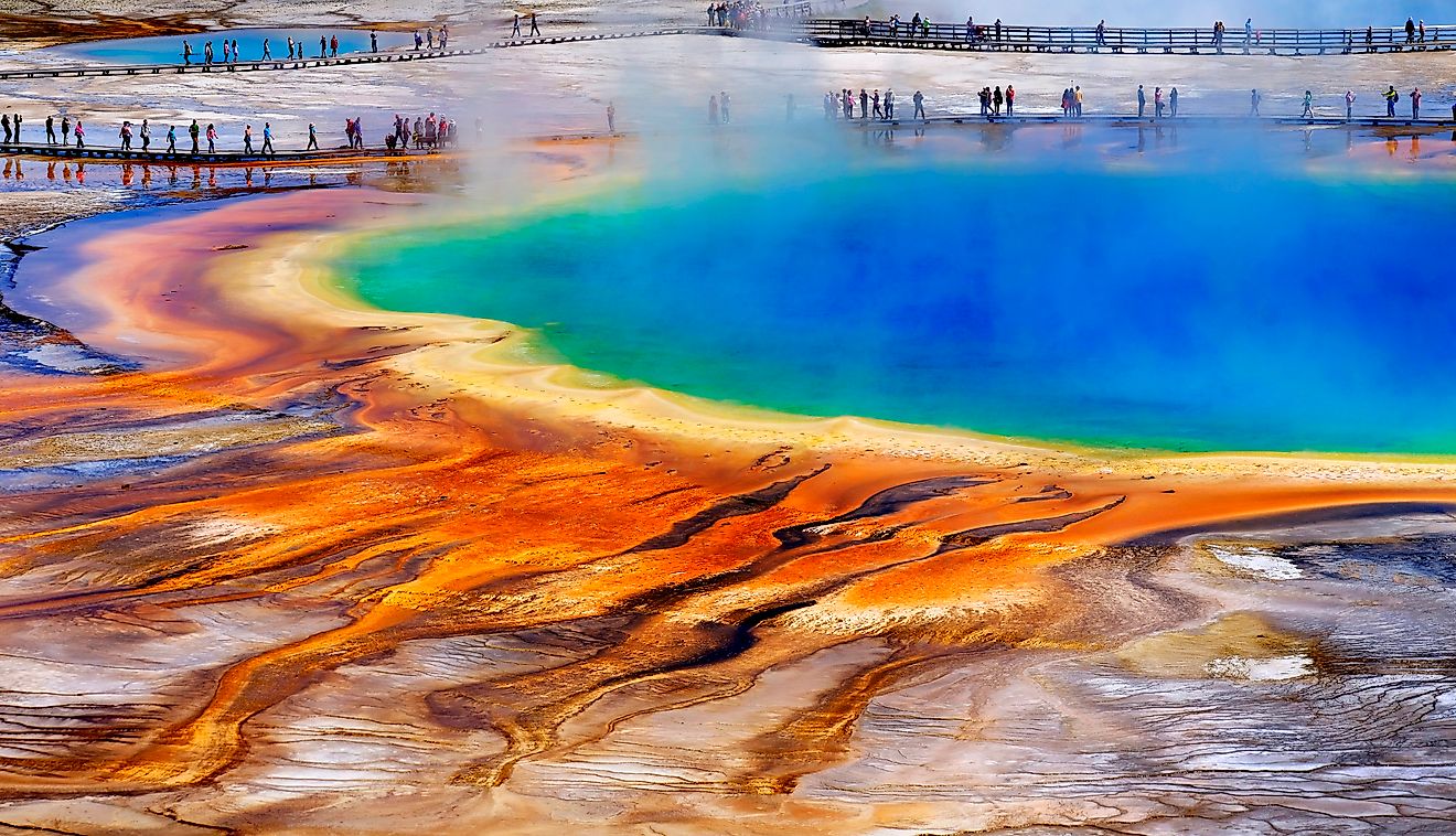 Grand Prismatice Spring in Yellowstone National Park with tourists viewing the spectacular natural scene