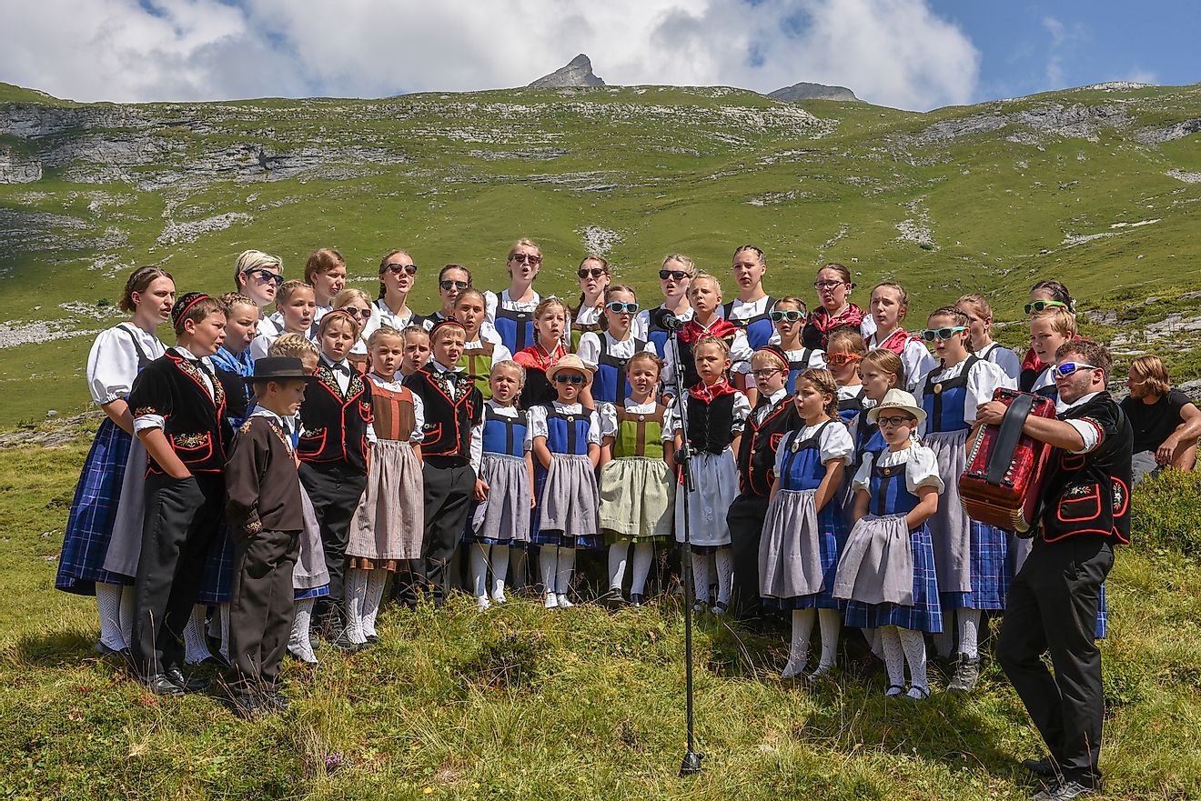 People wearing traditional clothes yodeling at Engstlenalp on the Swiss alps. Image credit: Stefano Ember/Shutterstock.com