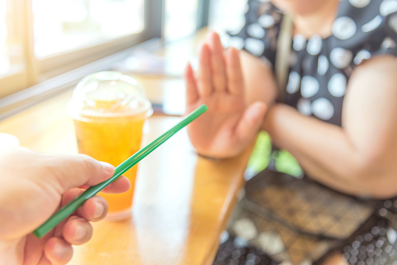 A woman says "no" to a plastic straw offered to her.