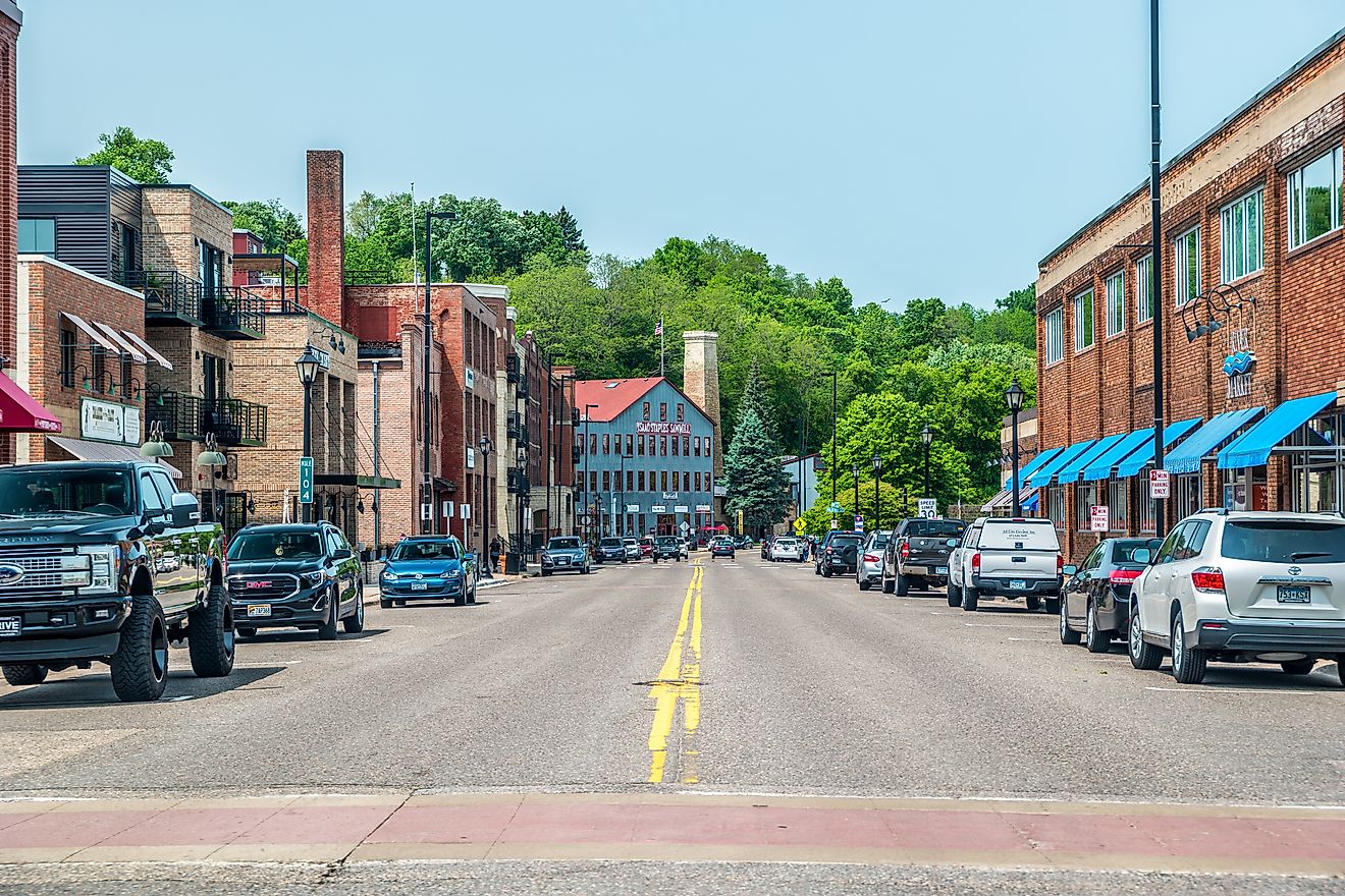 Street view of the downtown stores and restaurants in historic buildings and cars parked alongside on a sunny day in