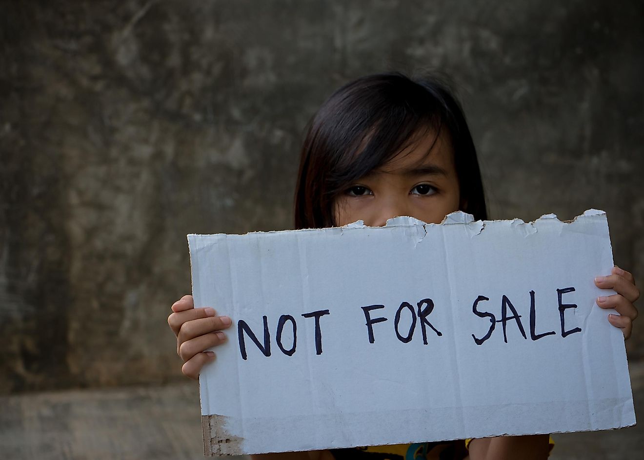 A child holding a ''Not for sale'' sign.
