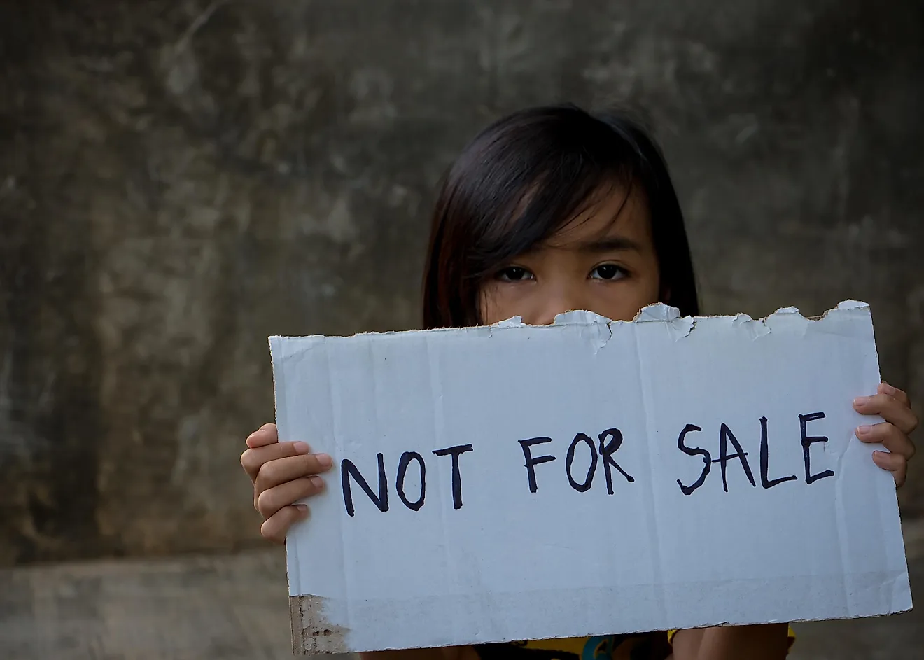 A child holding a ''Not for sale'' sign.