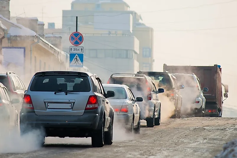 Combustion emissions spew from these cars traveling along a city street.