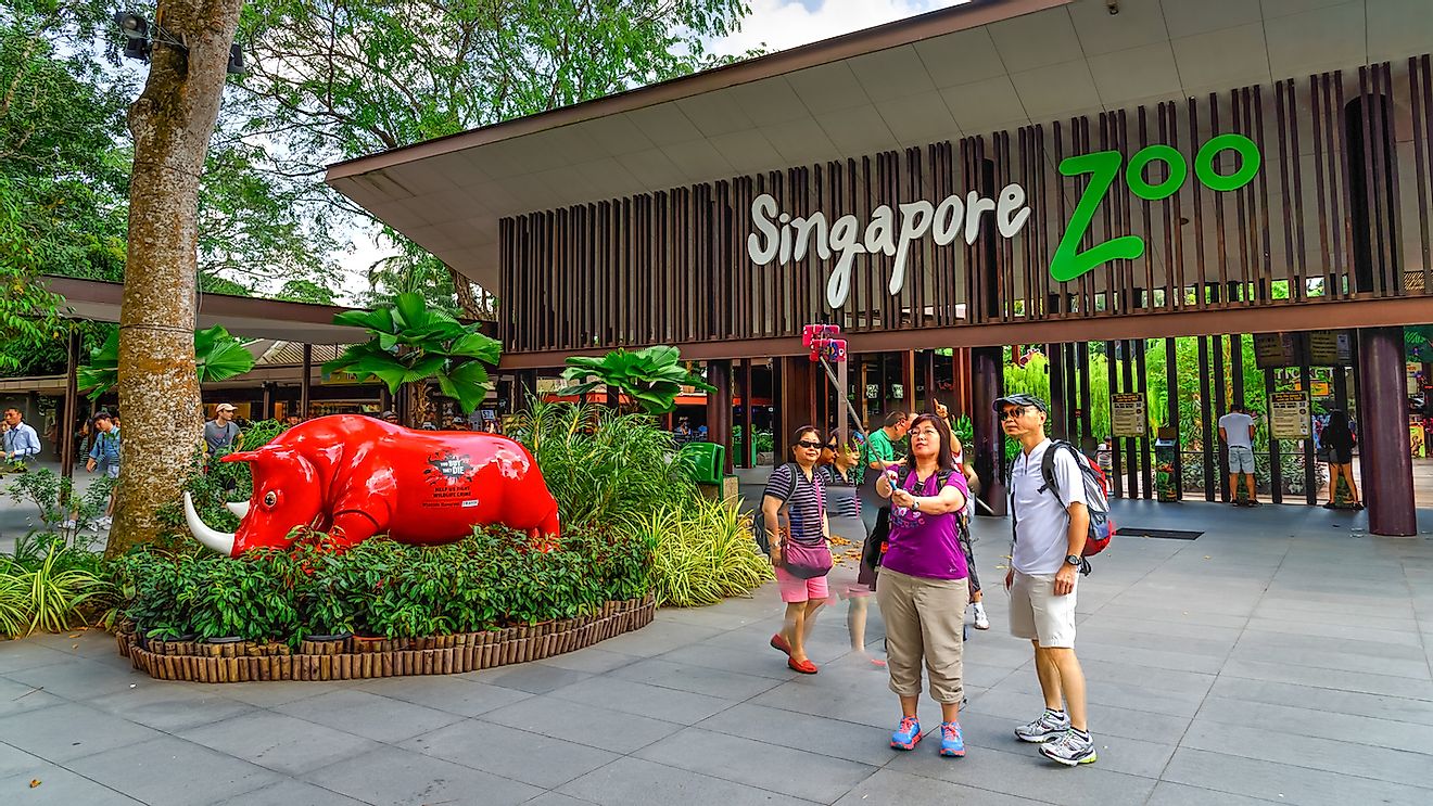 Visitors using smartphone, camera and selfie stick to take photo at the entrance of Singapore Zoo. With 315 species of animal, the zoo attracts 1.7 million visitors each year. Image credit: Trong Nguyen/Shutterstock.com