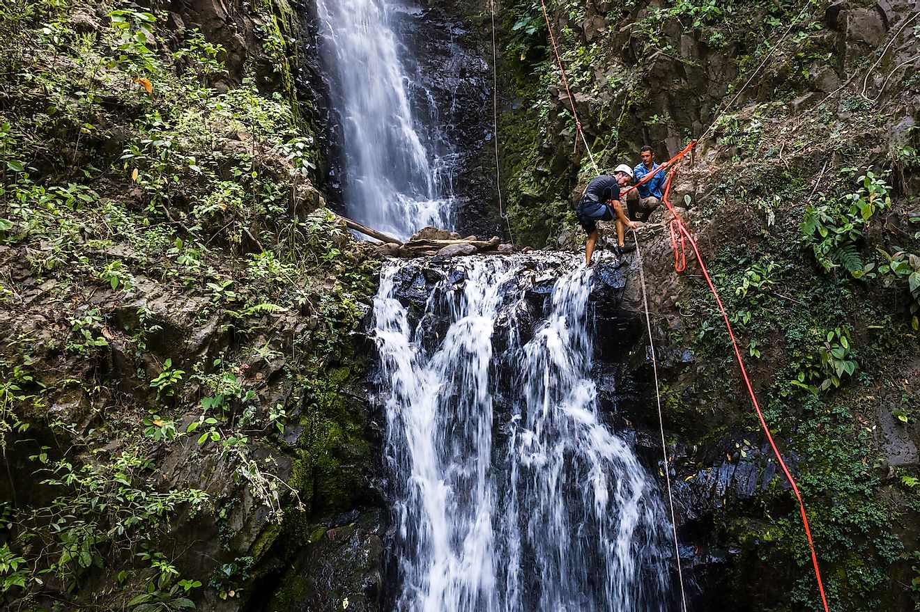 Adventure tourism in tropical Costa Rica while rappelling down a beautiful waterfall deep in the southern mountains of the country. Image credit: Wollertz/Shutterstock.com