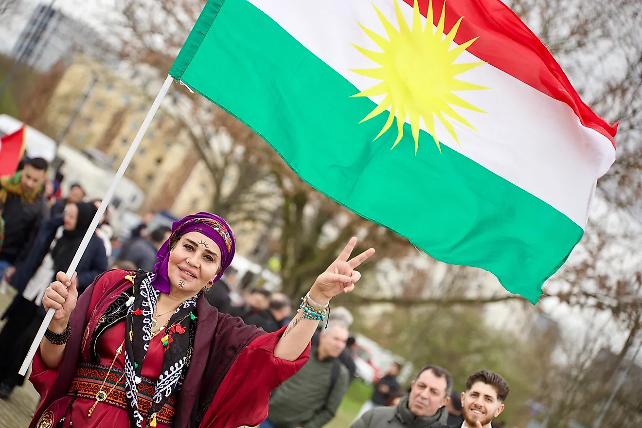Kurdish woman with Kurdish flag. Via Shutterstock / Mahmoud Mahdi Photo