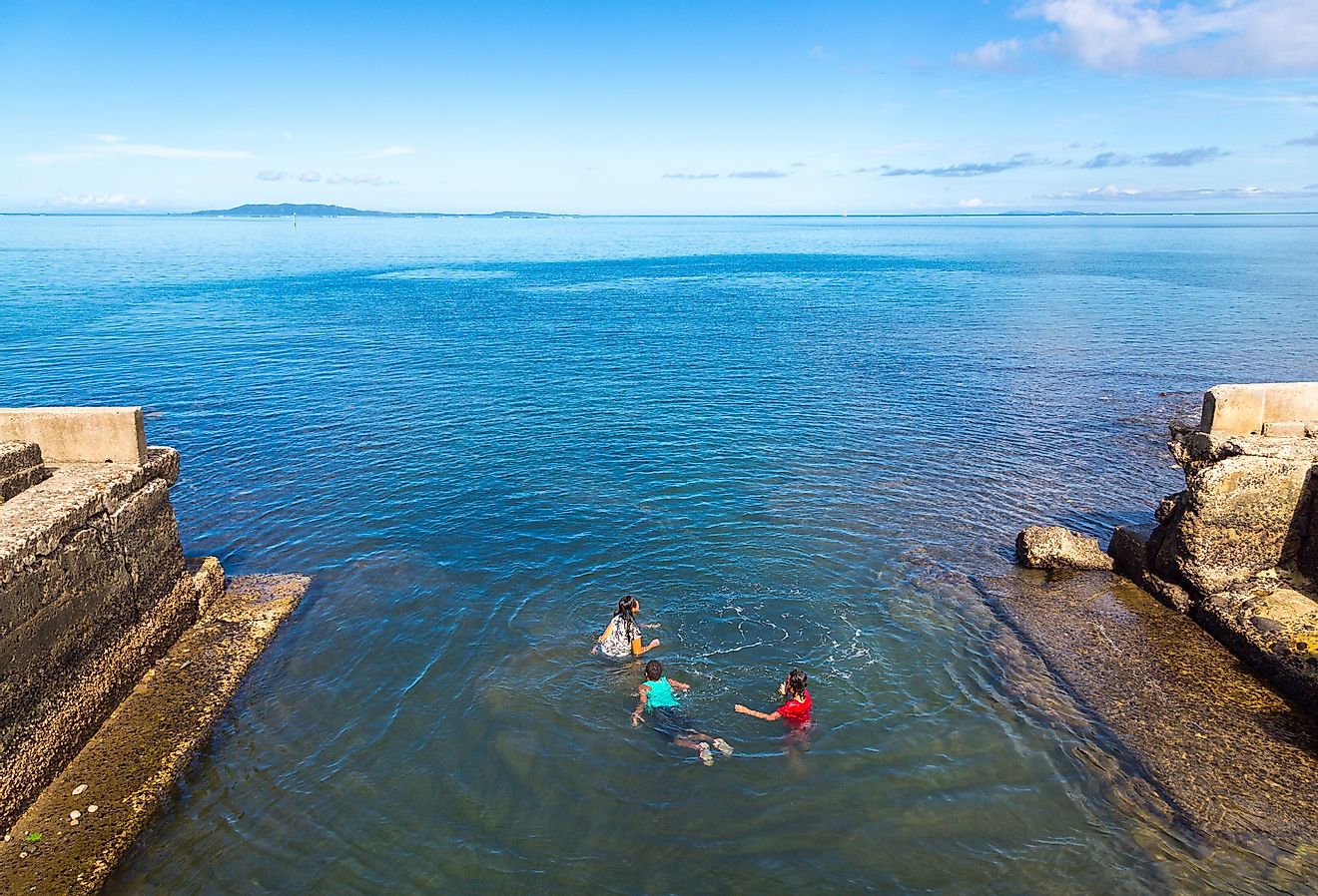 Indigenous fijian Melanesian kids are swimming off the embankment, Ovalau island, Lomaiviti archipelago, Fiji. Image credit maloff via Shutterstock