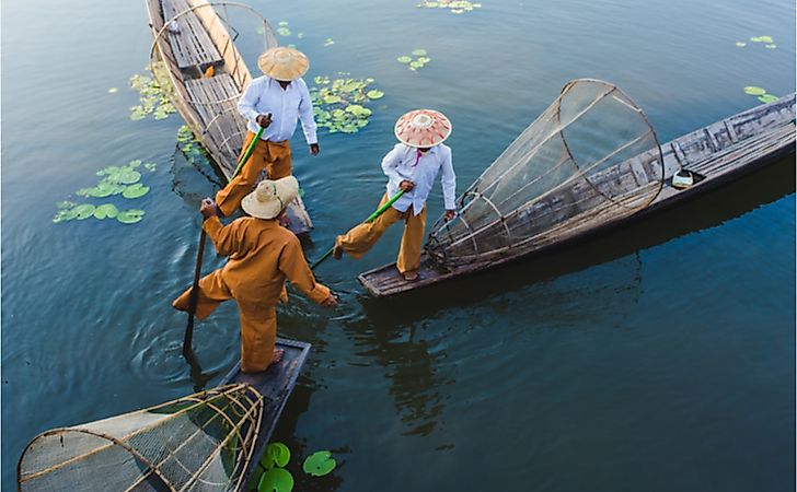 Burmese fishermen on Inle Lake stand on one leg while fishing, a unique skill developed over generations.