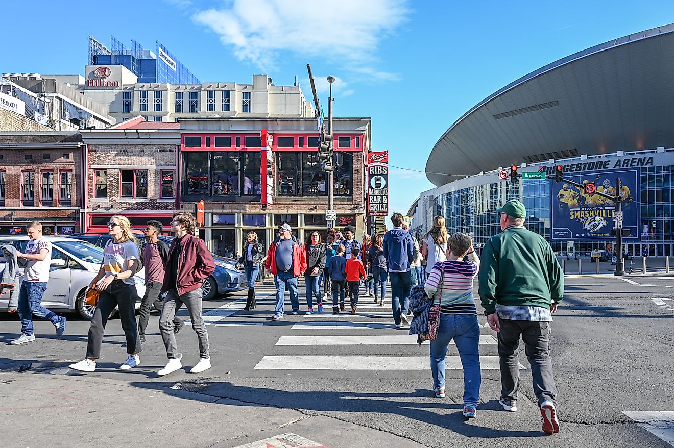 Pedestrians in Nashville, Tennessee, with Nashville Arena in the background. 